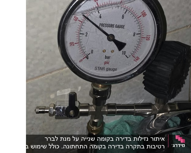 מד לחץ מים על קיר עם צינור